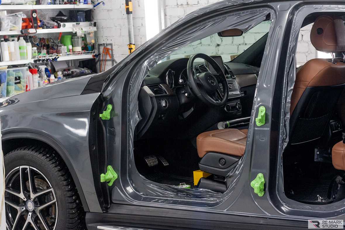 На фото промежуточный этап оклейки правой стороны автомобиля цельным куском виниловой пленки.